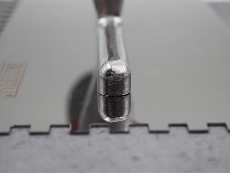 A Faithfull notched tile trowel with 6mm notches for combing adhesive on floors and walls, ensuring even coverage beneath tiles.