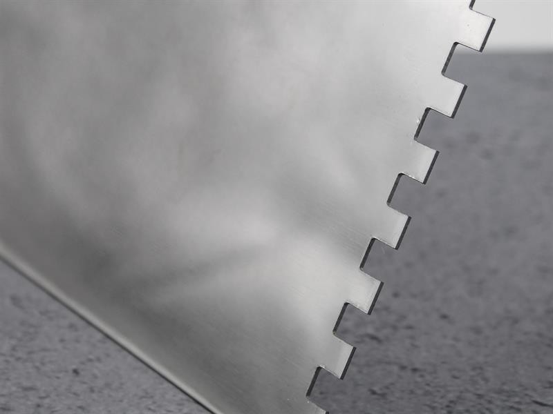 A Faithfull notched tile trowel with 6mm notches for combing adhesive on floors and walls, ensuring even coverage beneath tiles.