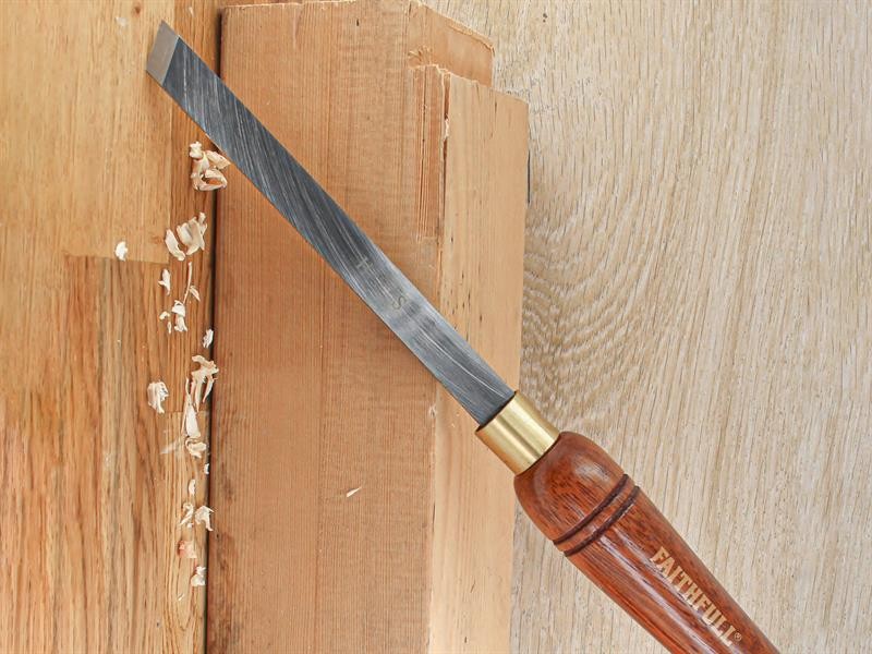 A hardened steel chisel with a bevelled cutting edge and a square-section body, for cutting stone, brick, or timber.