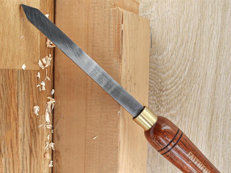 A hardened steel chisel with a bevelled cutting edge and a square-section body, for cutting stone, brick, or timber.