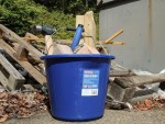 A heavy-duty plastic site bucket with a sturdy carry handle and measurement markings on the interior, for mixing and transporting materials.
