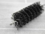 A brush with natural or synthetic bristles and an ergonomic handle, for applying coatings or cleaning surfaces.
