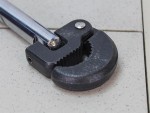 A Faithfull basin wrench with a swivelling jaw on a long telescopic shaft, for tightening and removing tap back-nuts in confined under-sink spaces.