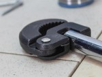 A Faithfull basin wrench with a swivelling jaw on a long telescopic shaft, for tightening and removing tap back-nuts in confined under-sink spaces.