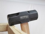 A 3.18kg sledgehammer with a heavy steel head and a long wooden handle, for heavy demolition, driving stakes, and breaking up masonry.