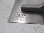 A Faithfull plasterer's finishing trowel with a thin, flexible steel blade and a turned wooden handle, for achieving smooth plaster surfaces.