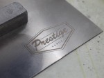 A Faithfull plasterer's finishing trowel with a thin, flexible steel blade and a turned wooden handle, for achieving smooth plaster surfaces.