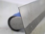 A Faithfull plasterer's finishing trowel with a thin, flexible steel blade and a turned wooden handle, for achieving smooth plaster surfaces.
