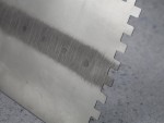 A Faithfull notched tile trowel with 115mm notches for combing adhesive on floors and walls, ensuring even coverage beneath tiles.