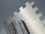A Faithfull notched tile trowel with 115mm notches for combing adhesive on floors and walls, ensuring even coverage beneath tiles.