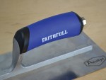 A Faithfull plasterer's finishing trowel with a thin, flexible steel blade and a turned wooden handle, for achieving smooth plaster surfaces.