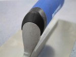 A Faithfull plasterer's finishing trowel with a thin, flexible steel blade and a turned wooden handle, for achieving smooth plaster surfaces.