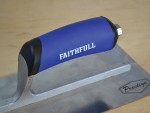 A Faithfull plasterer's finishing trowel with a thin, flexible steel blade and a turned wooden handle, for achieving smooth plaster surfaces.