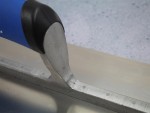 A Faithfull plasterer's finishing trowel with a thin, flexible steel blade and a turned wooden handle, for achieving smooth plaster surfaces.