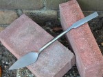 A Faithfull trowel with a polished steel blade and an ergonomic handle, for applying and finishing mortar, plaster, and adhesive.