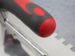 A Faithfull notched tile trowel with 10mm notches for combing adhesive on floors and walls, ensuring even coverage beneath tiles.
