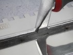 A Faithfull notched tile trowel with 10mm notches for combing adhesive on floors and walls, ensuring even coverage beneath tiles.