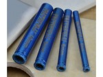 Four blue Faithfull diamond drill bits of varying diameters (10mm, 8mm, 6mm, 5mm) lying on a light surface, with textured tips for cutting through hard materials.