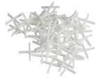 A pile of white plastic tile spacers arranged in a random heap on a white background.,