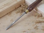 A hardened steel chisel with a bevelled cutting edge and a square-section body, for cutting stone, brick, or timber.